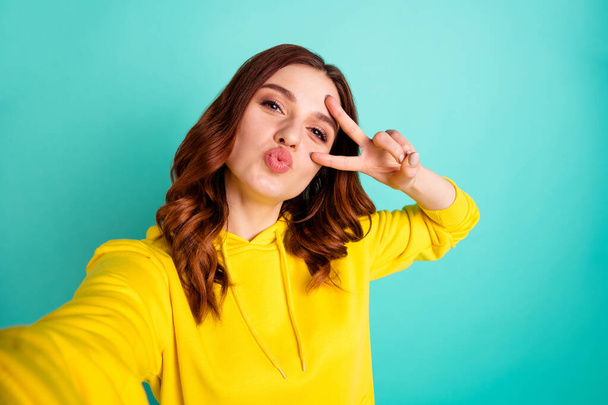 Photo of charming cute cheerful nice funky funny youngster taking selfie kissing you showing v-sign isolated over teal vibrant color background - Photo, Image
