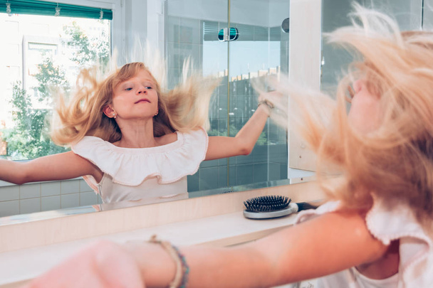 Kind hat Spaß mit langen blonden Haaren - Foto, Bild