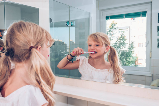 μικρό παιδί βουρτσίζει τα δόντια στο μπάνιο - Φωτογραφία, εικόνα