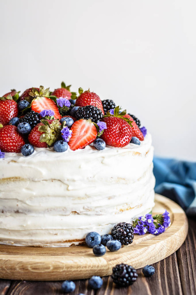 rustikale Torte mit frischen Beeren auf einem hölzernen Hintergrund - Foto, Bild
