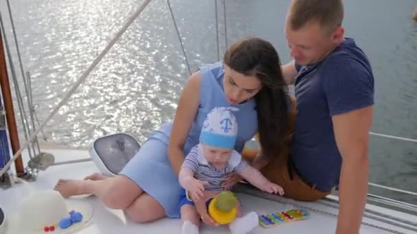 Karı koca zevk teknesinde dinlenen bebekle eşleşiyorlar. Eşi ve çocuğu gölde gülümseyen adamlar., - Video, Çekim