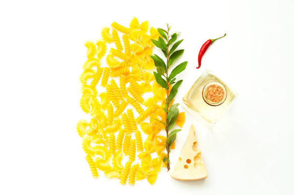 Diverse ongekookte pasta met ingrediënten geïsoleerd op witte achtergrond gr. - Foto, afbeelding