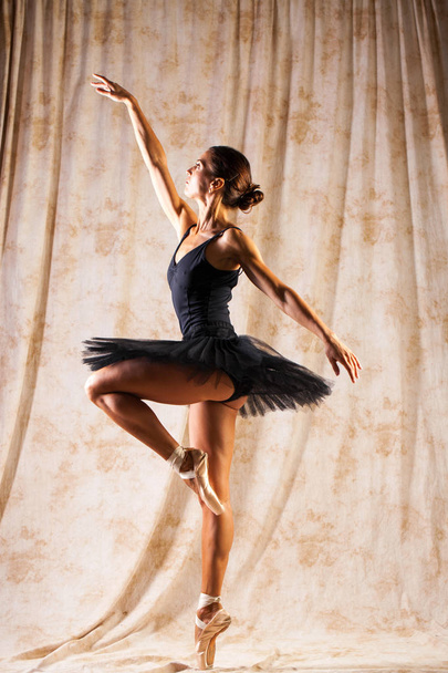 Full body portrait. Russian ballerina in a black dancing suit is - Zdjęcie, obraz
