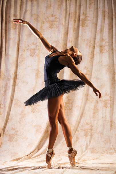 Full body portrait. Russian ballerina in a black dancing suit is - Фото, зображення