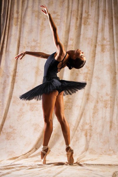 Full body portrait. Russian ballerina in a black dancing suit is - Fotó, kép