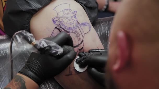 Профессиональный татуировщик делает татуировку на руке мужчины
. - Кадры, видео