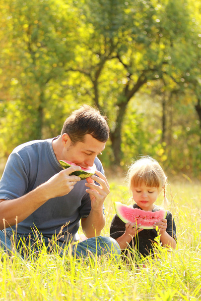 father and young daughter eat watermelon in nature - Foto, Imagem