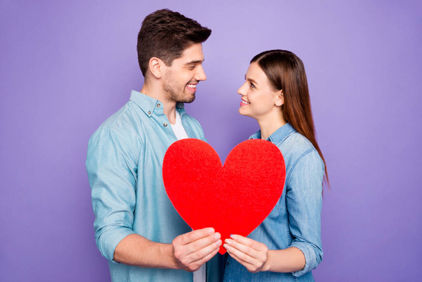 Profile side photo of romantic two students married couple hold paper card heart sign of feelings gift for 14-february honeymoon wear denim jeans outfit isolated over purple violet color background - Fotoğraf, Görsel