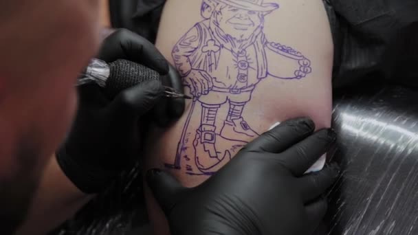 Επαγγελματίας καλλιτέχνης τατουάζ κάνει ένα τατουάζ στο χέρι ενός άνδρα. - Πλάνα, βίντεο
