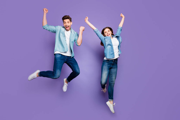Full length photo of cheerful funny funky students jump spouses raise fists scream yeah wear modern clothes white sneakers isolated over violet purple color background - Valokuva, kuva