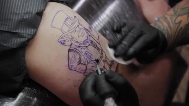 Profi tetováló művész csinál egy tetoválást egy férfi karjára. - Felvétel, videó