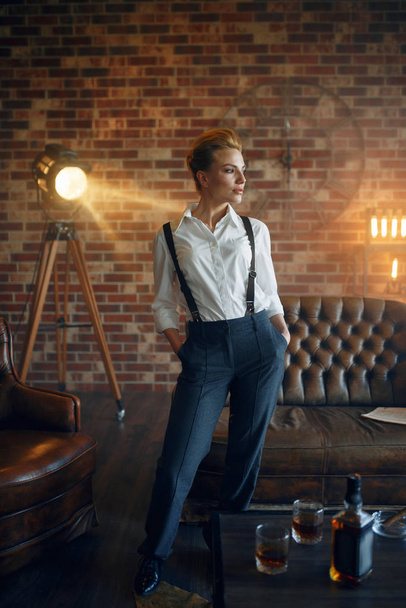 Elegant business woman in strict clothes poses in studio, retro fashion, gangster style, mafia. Vintage lady in office with brick walls - Photo, image