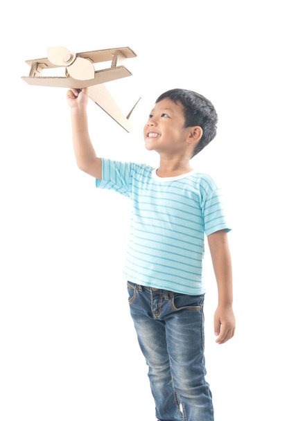 kid dreams as pilot standing and holding airplane paper isolated - Foto, Bild