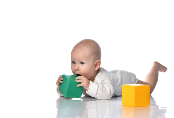 Дитячий малюк, сидячи в підгузник з зелено-червоною освітньою цегляною іграшкою
  - Фото, зображення