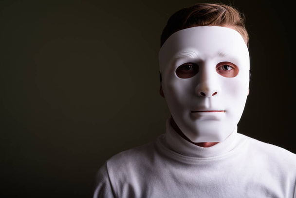 Mladý muž v bílém roláku svetr proti barevné záda - Fotografie, Obrázek