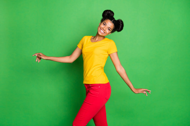 Profile photo of beautiful dark skin lady walking down street amazing sunny day weather wear casual yellow t-shirt and red pants isolated green background - Valokuva, kuva