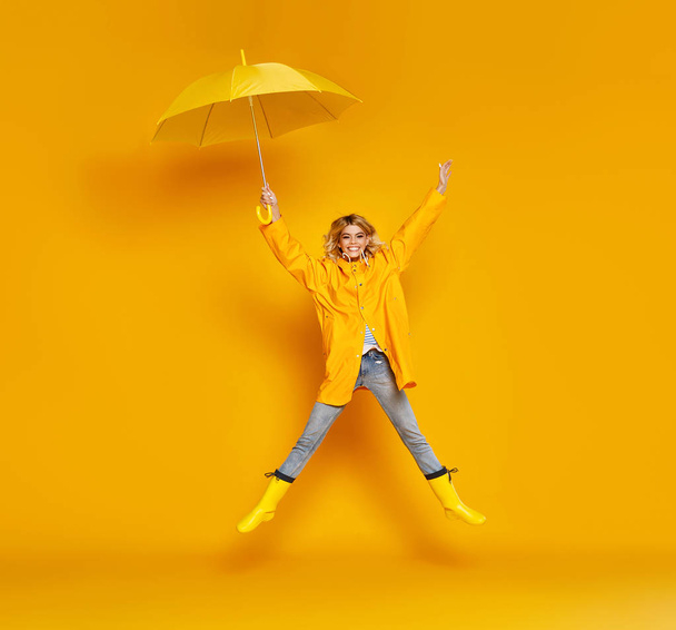 νεαρό χαρούμενο συναισθηματικό κορίτσι γελώντας με ομπρέλα σε έγχρωμο  - Φωτογραφία, εικόνα