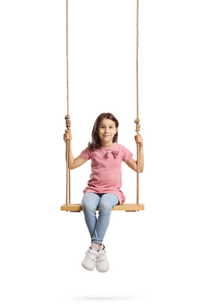 Happy little girl sitting on a wooden swing - 写真・画像