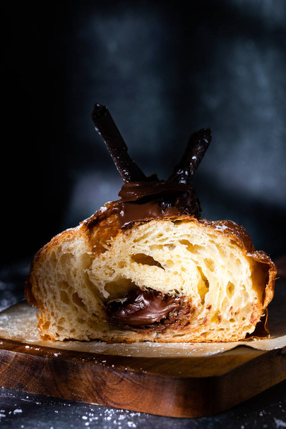 Chocolade croissant met chocolade vulling sijpelt uit in het midden - Foto, afbeelding