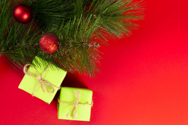 Christmas composition. Green gift boxes under the Christmas tree on a red background. View from above. a Christmas gift - Fotoğraf, Görsel