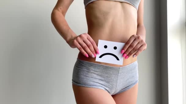 Zdraví ženy. Ženské tělo drží smutný úsměv kartu v blízkosti žaludku - Záběry, video