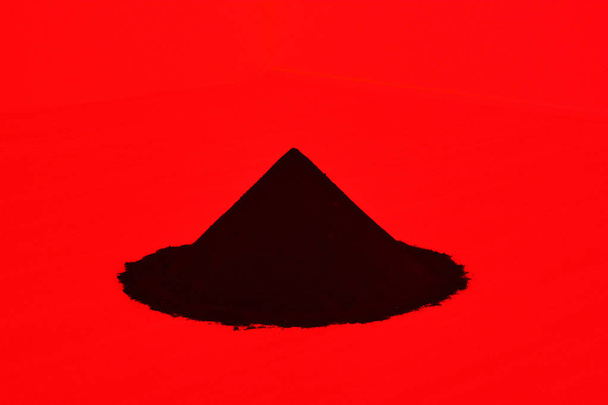 Dark blue heap of sand in a red room - Foto, afbeelding