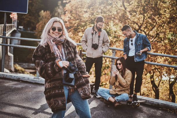 Beautiful blond girl and her friends at autumn park - Fotoğraf, Görsel