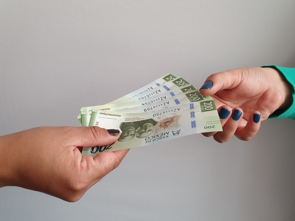 women hands paying and receiving Mexican money - 写真・画像