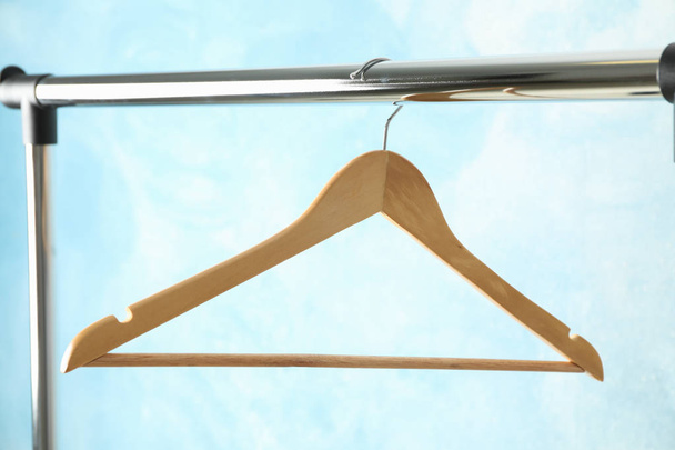 Hanger on rod against blue background, copy space - Photo, Image