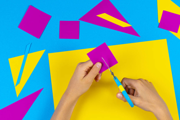 Childs mãos cortando papel colorido com tesoura na mesa
 - Foto, Imagem