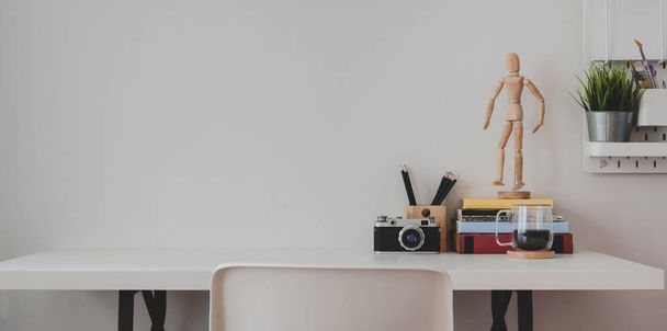 Bureau à domicile minimaliste avec fournitures et décorations de bureau sur fond de table en bois blanc et mur blanc
  - Photo, image