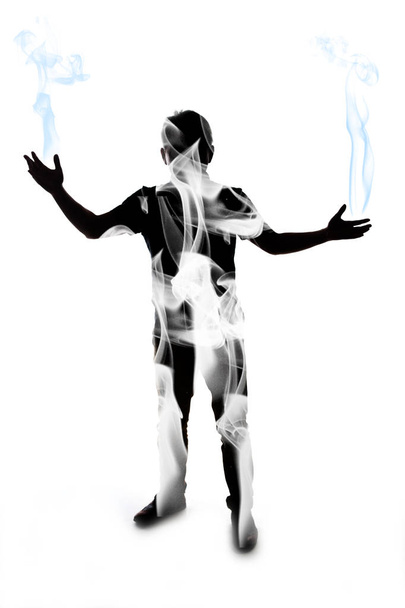 Hombre entrenando y haciendo posiciones de artes marciales; silueta de un hombre sobre fondo blanco del que sale humo de sus manos
. - Foto, imagen