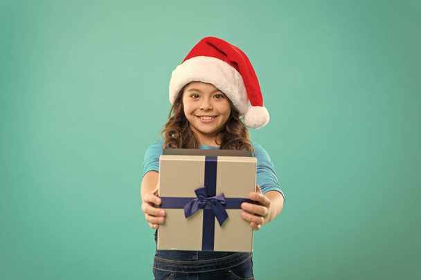 Happy winter holidays. Small girl. Present for Xmas. Childhood. New year party. Santa claus kid. Christmas shopping. Little girl child in santa hat. Thank you. What a great surprise - Photo, Image
