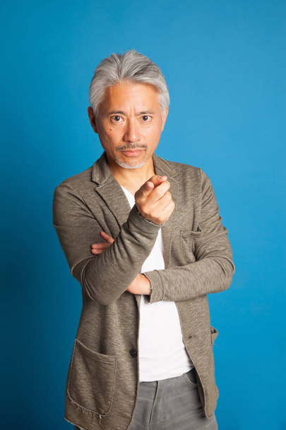 Middle-aged man of Japanese origin, gesturing with his arms and hands; expressive man. - Фото, зображення