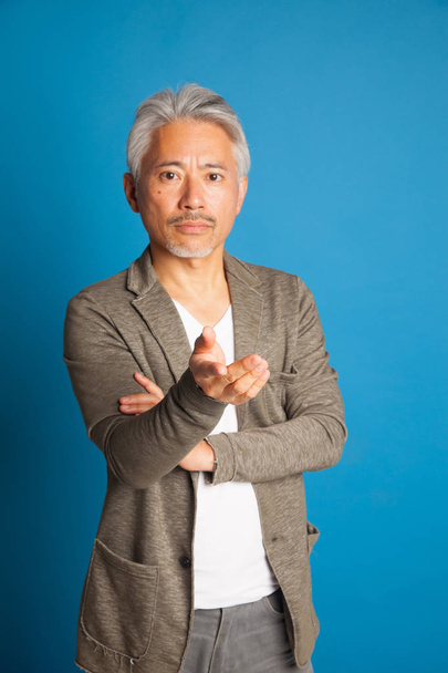 Homme d'âge moyen d'origine japonaise, geste avec les bras et les mains ; homme expressif
. - Photo, image