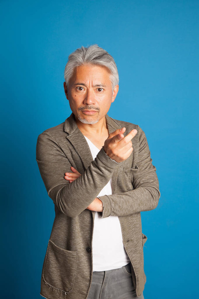 Homme d'âge moyen d'origine japonaise, geste avec les bras et les mains ; homme expressif
. - Photo, image