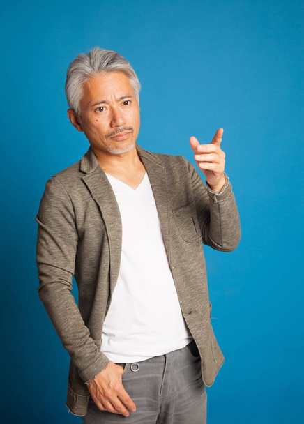 Man van middelbare leeftijd van Japanse afkomst, gebarentaal met armen en handen; expressieve man. - Foto, afbeelding