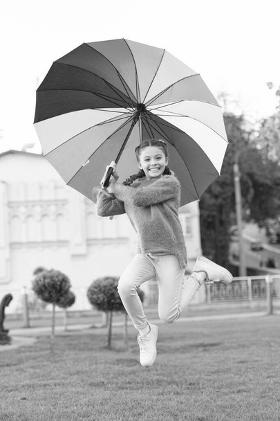 Happy and free. cheerful child. Spring style. Rainbow after rain. Little girl under colorful umbrella. Positive mood in autumn weather. Multicolored umbrella for little happy girl. Feeling happy - Fotografie, Obrázek