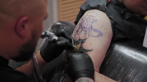 Profesjonalny tatuażysta robi tatuaż na męskiej ręce. - Materiał filmowy, wideo