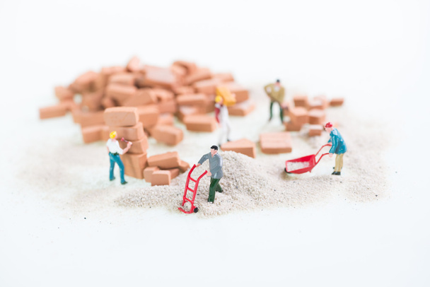 Miniature workmen doing construction brick work top view - Photo, Image