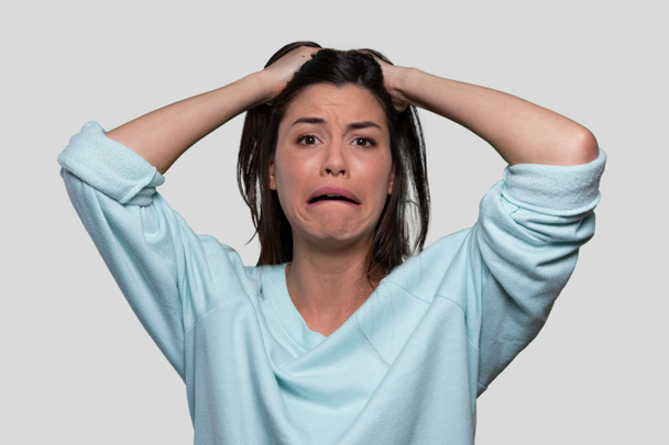 Mujer angustiada e indefensa sosteniendo su cabeza sufriendo de dolor mental, ansiedad, desequilibrio hormonal, expresión asustada
 - Foto, imagen