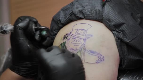 Artista profesional del tatuaje hace un tatuaje en el brazo de un hombre
. - Imágenes, Vídeo