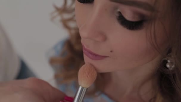 mooi jong meisje maakt make-up kunstenaar. - Video