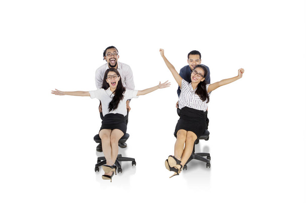 Group of excited business people racing on chairs - Foto, Imagem