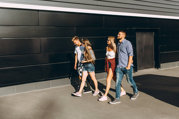Group of stylish friends, girls and guys walk together on in the city - 写真・画像