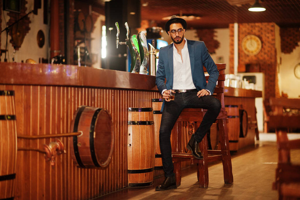 Handsome well-dressed arabian man with glass of whiskey and ciga - Photo, image