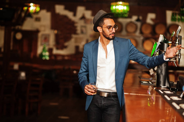 Handsome well-dressed arabian man with glass of whiskey and ciga - Foto, Imagen