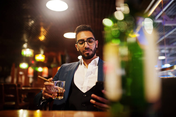 Handsome well-dressed arabian man with glass of whiskey and ciga - Photo, image