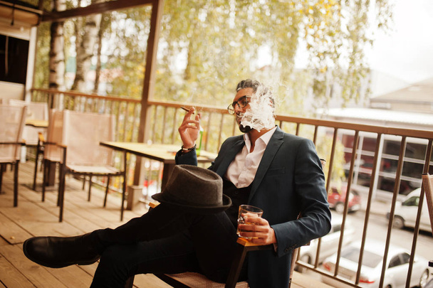 Handsome well-dressed arabian man smoke cigar with glass of whis - Fotoğraf, Görsel