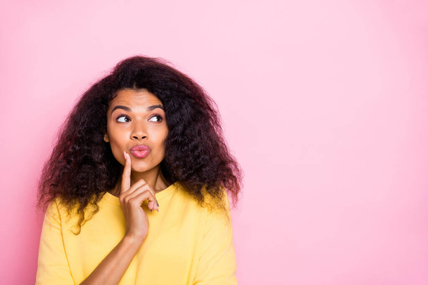 Portrait of minded interested afro american girl think have plans about future weeknds solve question wear yellow pullover isolated over pink color background - Фото, зображення